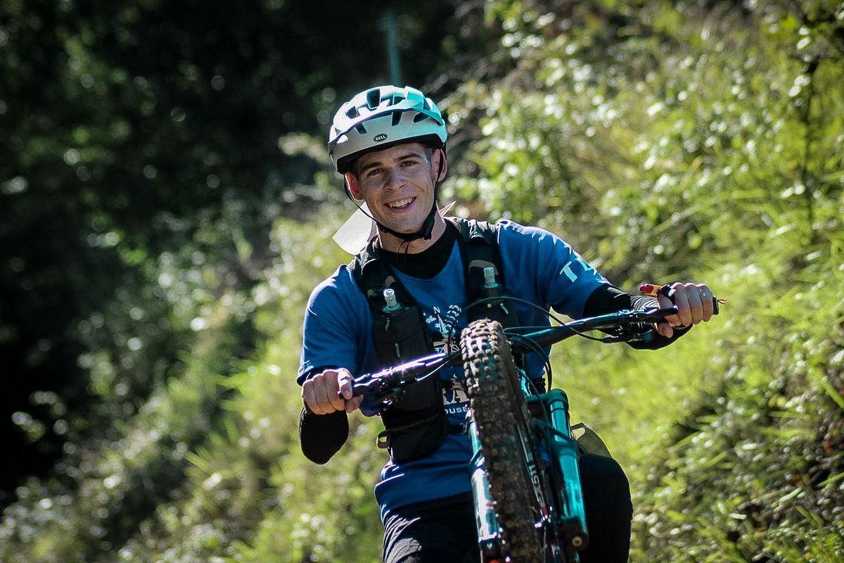 Vététiste souriant sur un single track en sous-bois